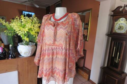 Stunning cream sleeveless polyester top with overlay in zig-zag autumn colours. Size 40/16.