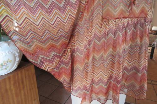 Stunning cream sleeveless polyester top with overlay in zig-zag autumn colours. Size 40/16.