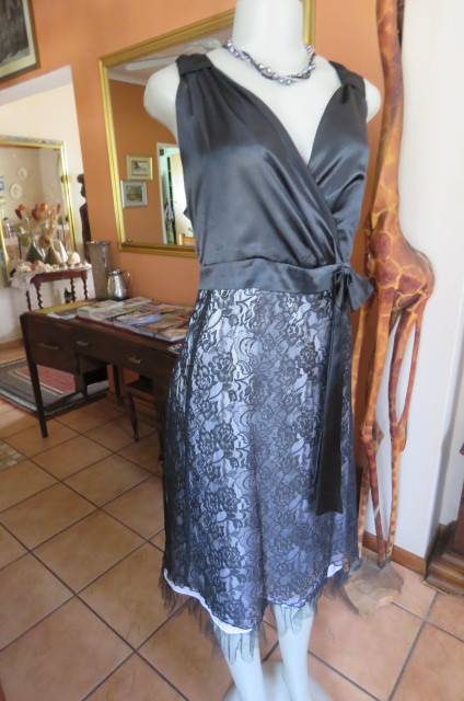 Smart black dress by `Donna Claire` in size 42/18. Cross over bust with ties.Satin top.