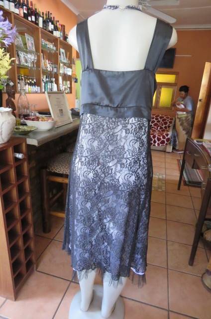 Smart black dress by `Donna Claire` in size 42/18. Cross over bust with ties.Satin top.