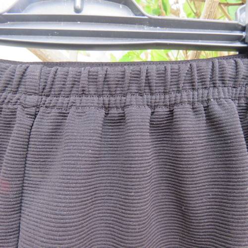 Little black ribbed polyester skirt. For girl 12 to 13 years old. Buckle on front. As new.