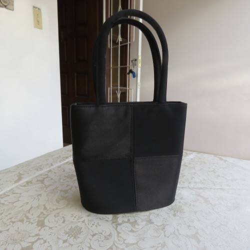 Small black bucket style handbag in shiny blocked vinyl .Size 18 x 16cm. As new