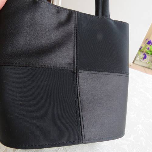 Small black bucket style handbag in shiny blocked vinyl .Size 18 x 16cm. As new