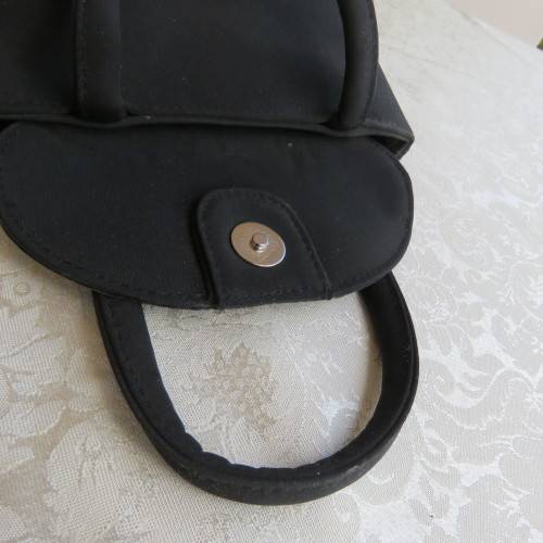 Small black bucket style handbag in shiny blocked vinyl .Size 18 x 16cm. As new
