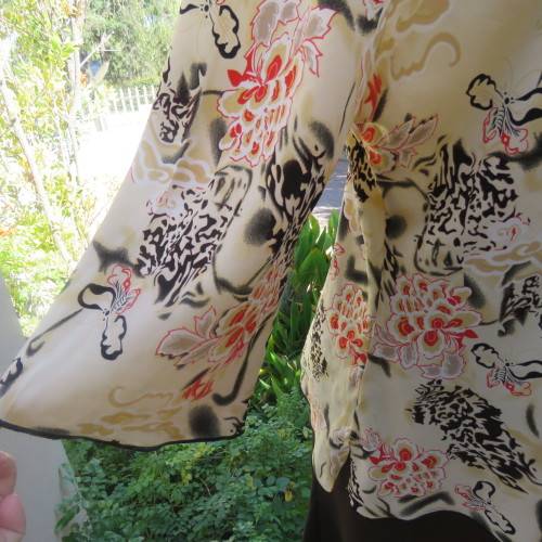 Pretty slip over silky polyester rich cream top with red and black unique designs.Size 44/20.As new