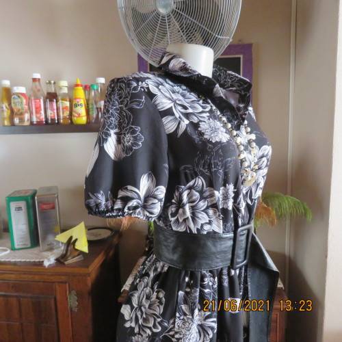 Pretty black and white floral 100% polyester dress with short sleeves.By OR size 34/10.Belt included