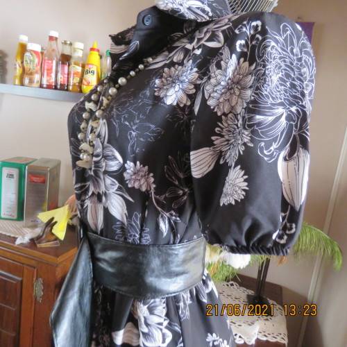 Pretty black and white floral 100% polyester dress with short sleeves.By OR size 34/10.Belt included