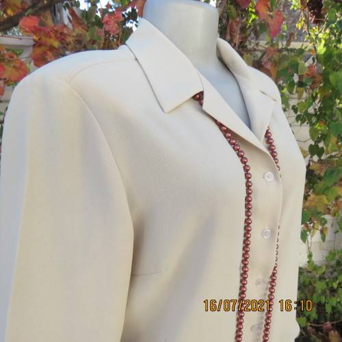 Stylish rich cream button down top in textured polyester.With flare sleeve cuffs. Size 42/18. As new