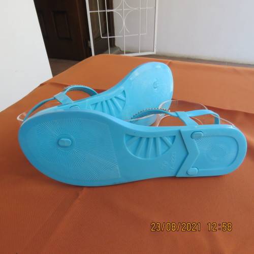 Pair of blue plastic sandals in size 7. Strap between toes and around ankle.Faux diamond decoration.