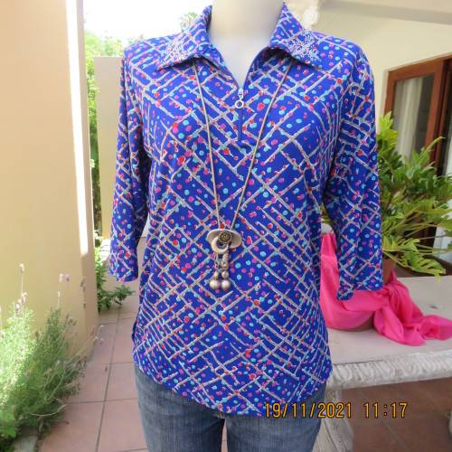 New blue patternened slip over stretch polyester top. Short front zip and embellished collar.Size 36