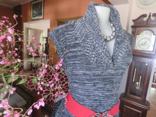 Stylish black/white mottled long acrylic knit sleeveless top.Foldover fireside collar.Size 36/12.