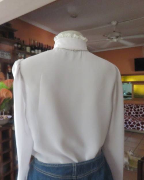 Stylish 80`s long sleeve button down light grey blouse with high banded collar.Size 32 by FOSHINI.