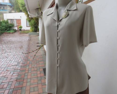 Elegant oyster beige short sleeve polyester top with open collar.Close with buttons/loops.Size 36