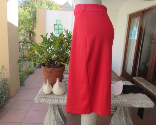 Smart red pencil skirt in red jersey fabric with some stretch.Size 42/18. Pleat at back. As new.
