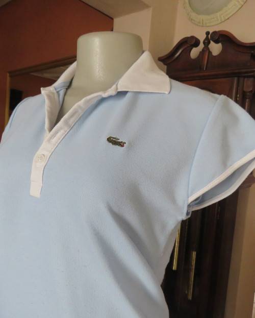 LACOSTE light blue top with white knitted collar and edging.Size 34 to 36.Opening in front.Good cond
