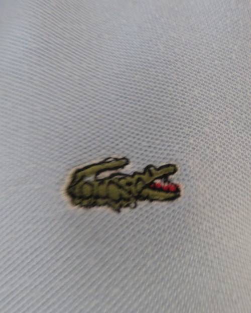LACOSTE light blue top with white knitted collar and edging.Size 34 to 36.Opening in front.Good cond