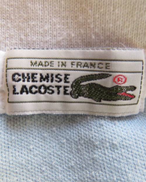 LACOSTE light blue top with white knitted collar and edging.Size 34 to 36.Opening in front.Good cond