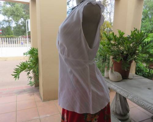 Sleeveless white 100%cotton embossed empire top.Crossover bust.Floral print decoration.42
