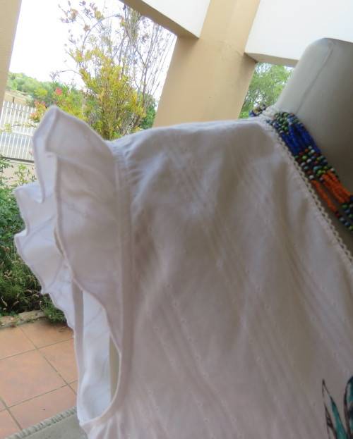 Sleeveless white 100%cotton embossed empire top.Crossover bust.Floral print decoration.42