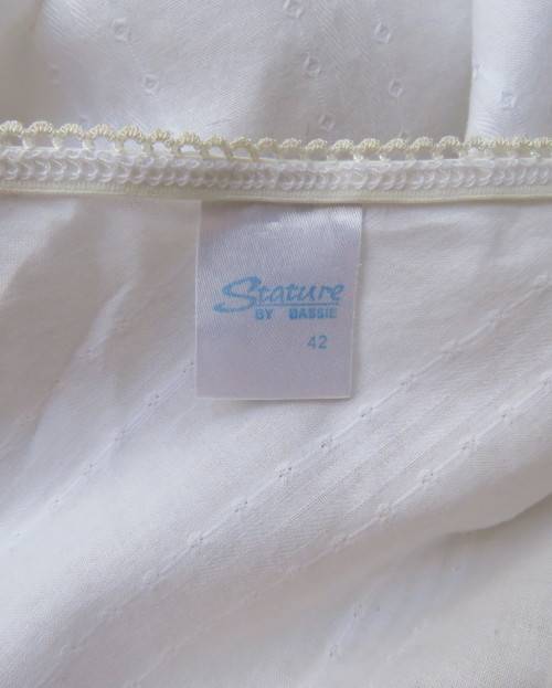 Sleeveless white 100%cotton embossed empire top.Crossover bust.Floral print decoration.42