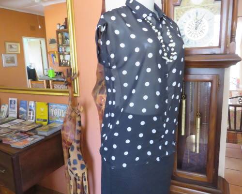 Sheer black and white polkadot button down top with tiny cut on sleeves. Size 34/10.As new cond.