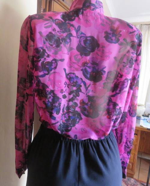 Eyecatching pink/purple floral long sleeve blouse.Hidden button down front and tie collar.Size36/12