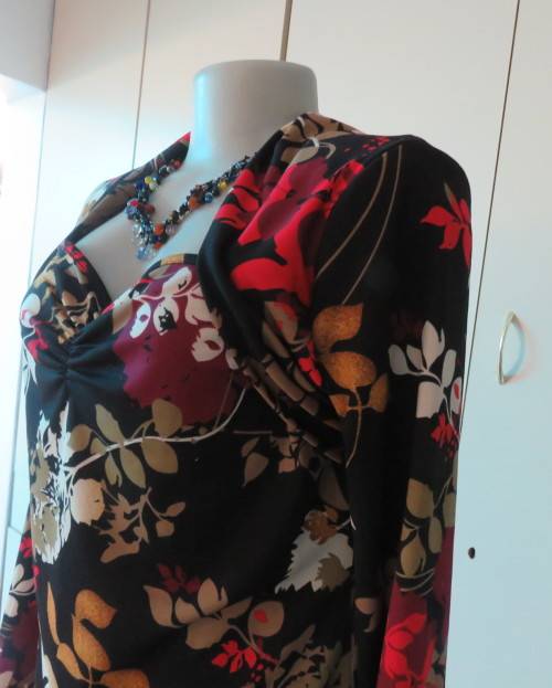 Black stretch polyester background with red,purple and gold floral pattern top.Tiny bolero.Size 38