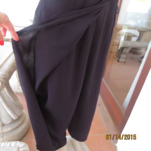 Elegant modern black jumpsuit with foldover skirt front. In 100% rayon.High collar.Size 38/14.As new