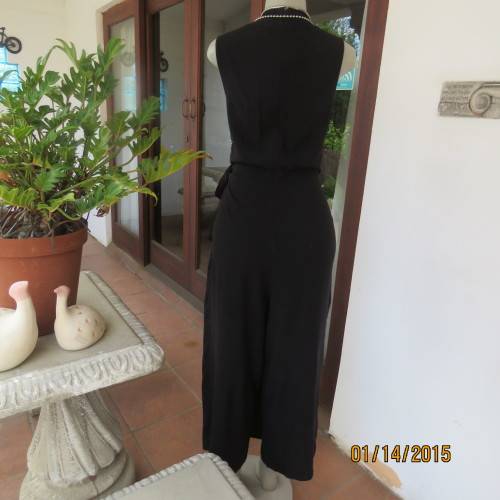 Elegant modern black jumpsuit with foldover skirt front. In 100% rayon.High collar.Size 38/14.As new
