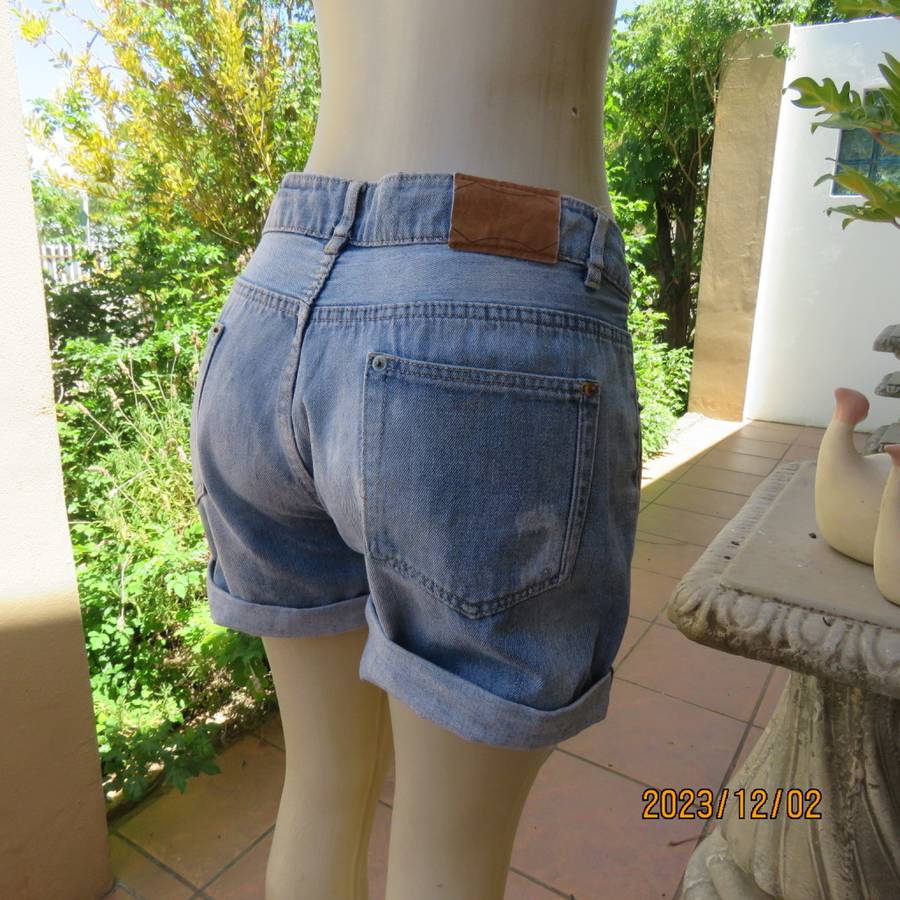 Distressed look denim shorts size 38/14 with turnover legs. Buttoned fly. Pockets back/front.
