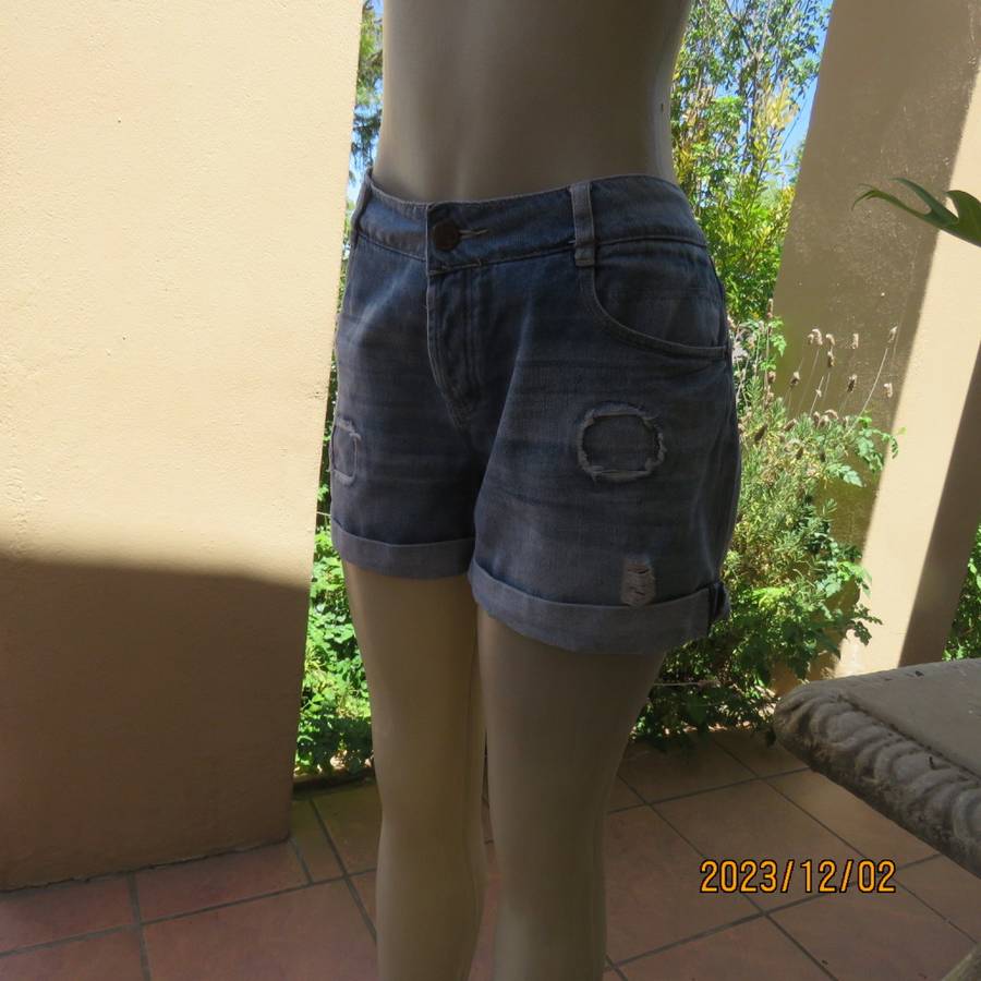 Distressed look denim shorts size 38/14 with turnover legs. Buttoned fly. Pockets back/front.