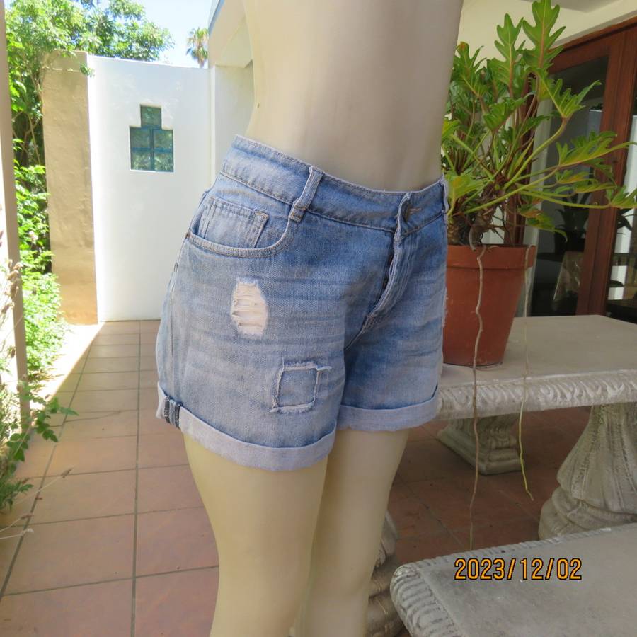 Distressed look denim shorts size 38/14 with turnover legs. Buttoned fly. Pockets back/front.