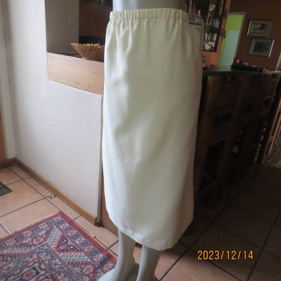 Easy to wear cream fully lined pencil skirt in textured polyester. Boutique made size 40. New cond.