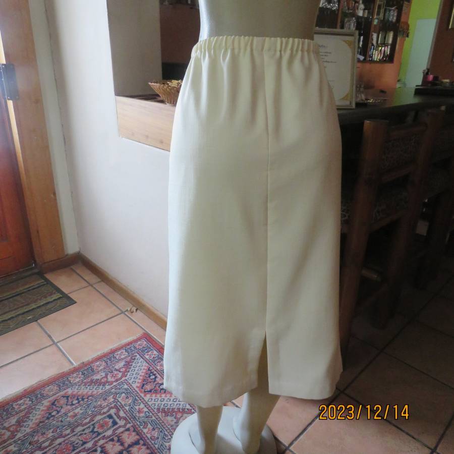 Easy to wear cream fully lined pencil skirt in textured polyester. Boutique made size 40. New cond.