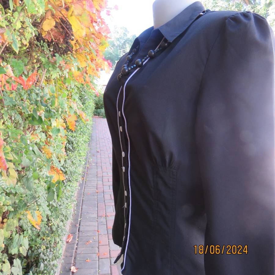 Charming long sleeves black tailored top. V button down front/collar. White edging/buttons.Size 36.