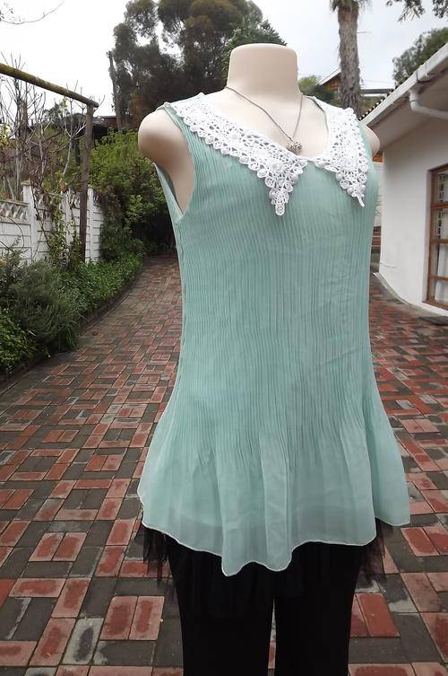 Pastel turquoise permanent pleated top with lining.Size 34/10 with beautiful cotton lace collar