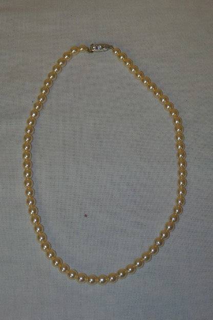 A BEAUTIFUL SINGLE STAND OF FASHION PEARLS WITH AN ELEGANT SILVER METAL CLASP WITH DIAMANTE
