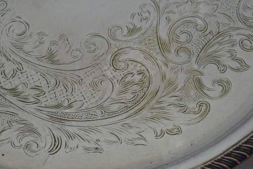 AN EXQUISITE VINTAGE SILVER PLATED ROUND FOOTED SERVING TRAY WITH STUNNING ORNATE ENGRAVED DETAILING