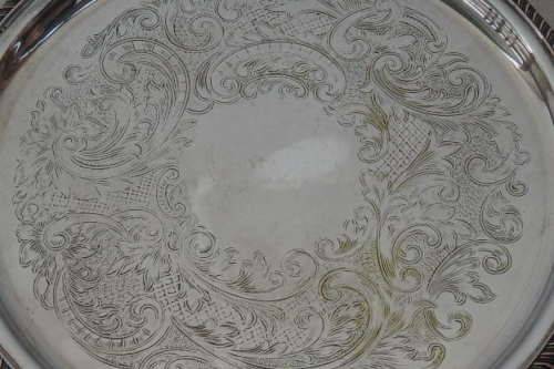 AN EXQUISITE VINTAGE SILVER PLATED ROUND FOOTED SERVING TRAY WITH STUNNING ORNATE ENGRAVED DETAILING