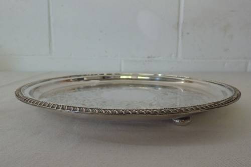 AN EXQUISITE VINTAGE SILVER PLATED ROUND FOOTED SERVING TRAY WITH STUNNING ORNATE ENGRAVED DETAILING