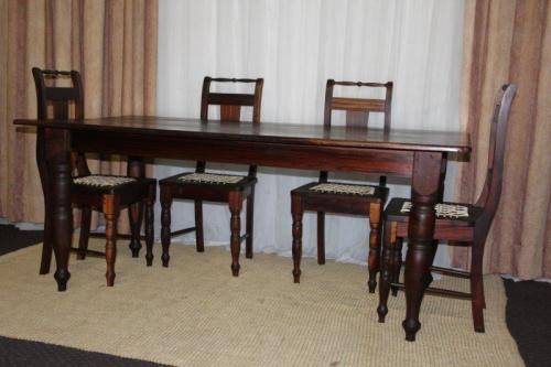 A SPECTACULAR SOLID STINKWOOD 6 TO 8-SEATER DINING TABLE WITH SOLID TURNED LEGS IN AWESOME CONDITION
