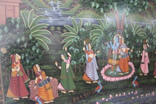 A STUNNING LARGE (1.5m x 1m) PAINTING OF THE HINDU GOD KRISHNA PLAYING THE FLUTE IN A GARDEN