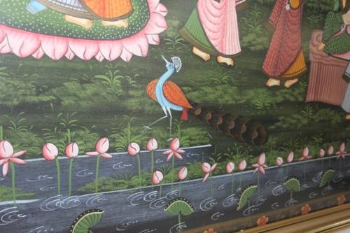 A STUNNING LARGE (1.5m x 1m) PAINTING OF THE HINDU GOD KRISHNA PLAYING THE FLUTE IN A GARDEN