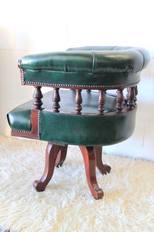 A spectacular solid mahogany "captain's swivel chair" with period British green upholstery