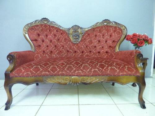 A spectacular hand carved Victorian couch with deep button detailing and rolled padded armrests!