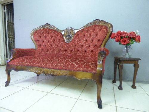 A spectacular hand carved Victorian couch with deep button detailing and rolled padded armrests!