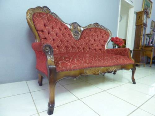 A spectacular hand carved Victorian couch with deep button detailing and rolled padded armrests!