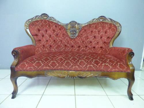 A spectacular hand carved Victorian couch with deep button detailing and rolled padded armrests!