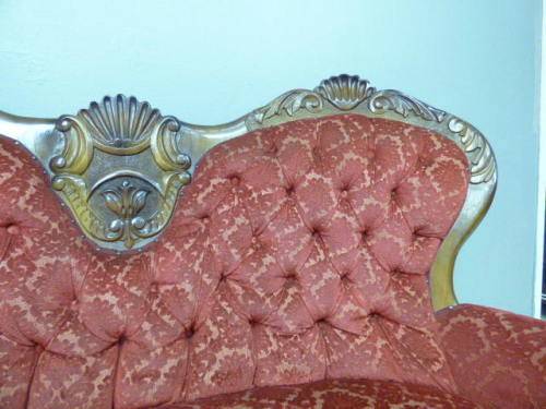 A spectacular hand carved Victorian couch with deep button detailing and rolled padded armrests!