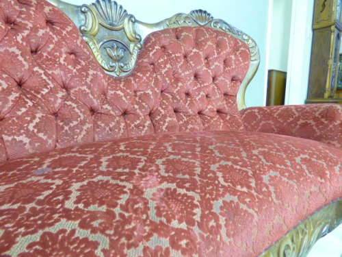 A spectacular hand carved Victorian couch with deep button detailing and rolled padded armrests!